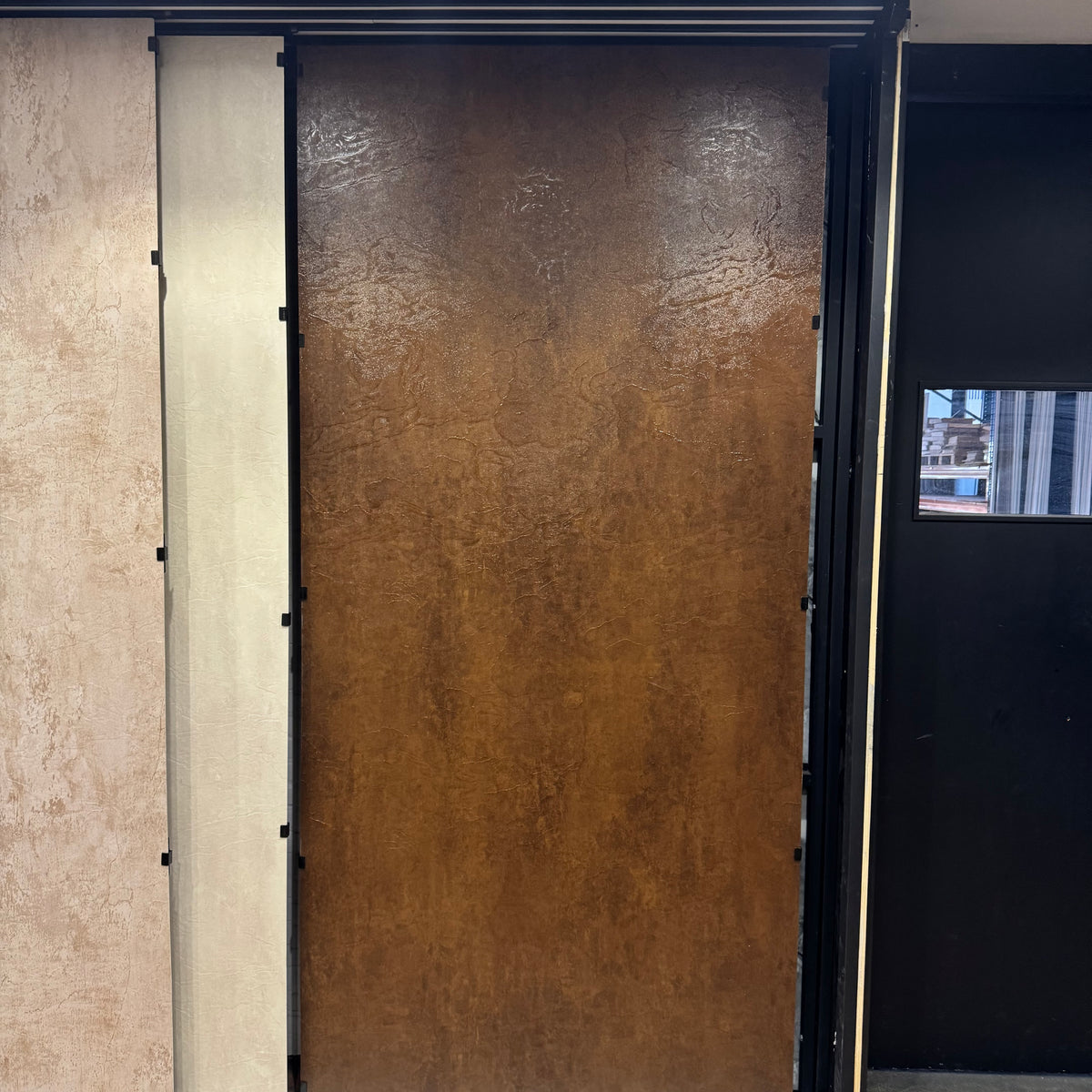 Showroom presentatie van een roestbruin SPC wandpaneel, tentoongesteld als losstaand display om de textuur en kleur van het paneel op de werkvloer te tonen.